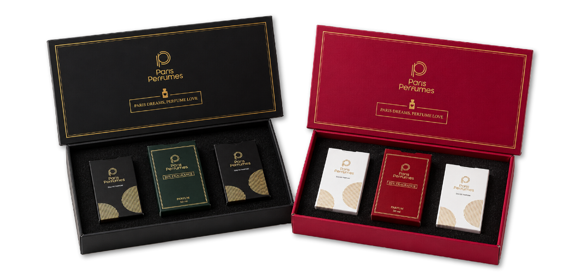 Dvi atidarytos Paris Perfumes dovanų dėžutės, juoda ir bordinė, kiekvienoje po tris buteliukus
